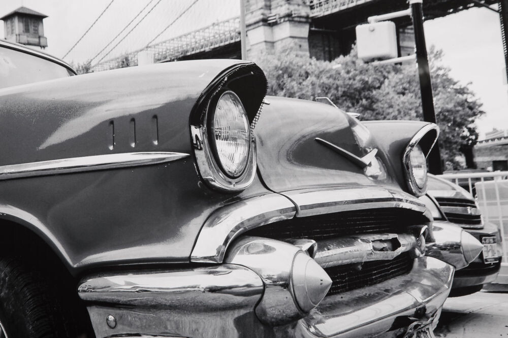 Постер с паспарту в раме Vintage car parked by city bridge